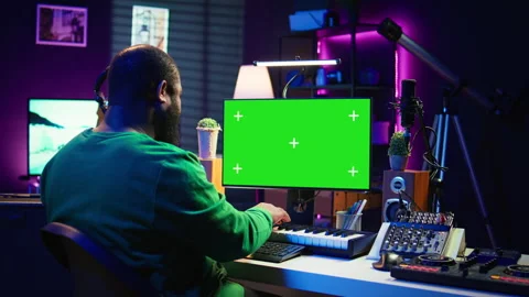 Artist plays midi controller synthesizer next to greenscreen layout Stock Footage 281452587