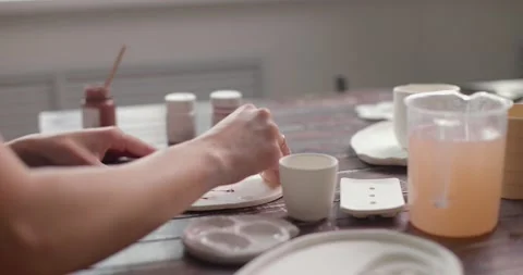 Artist potter creates a beautiful pattern on earthenware in a pottery workshop Stock Footage 155652753