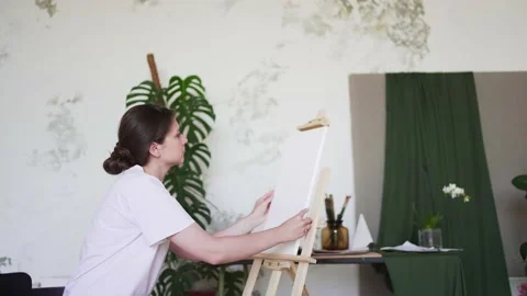 The artist prepares a workplace in a creative workshop. Female painter installs Stock Footage 156874401