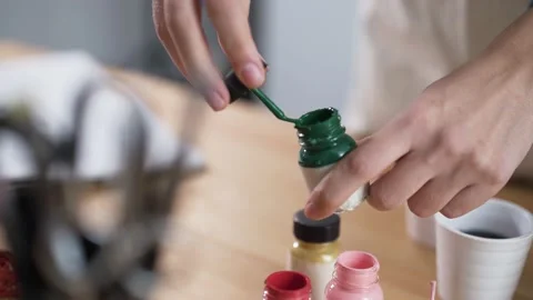 Artist preparing for work by opening paint pots in studio Stock Footage 133280328