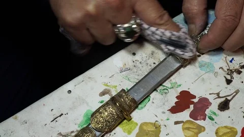 Artist restorer working on restoring the old Persian knife Stock Footage 82625701