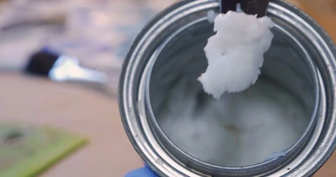 Artist scooping out paste or cold wax from a small can with a palette knife Stock Footage 120638662