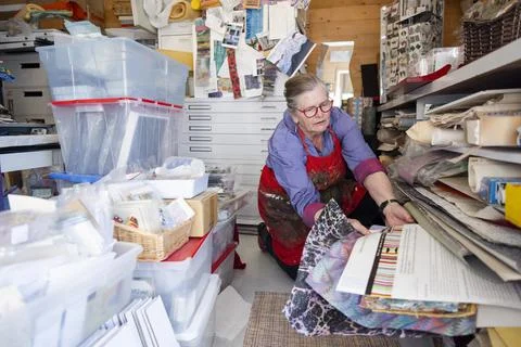 Artist selecting patterned paper from shelf Stock Photos