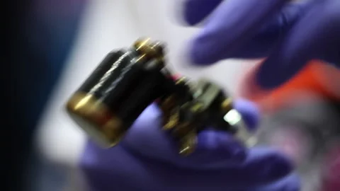 Artist setting up the tattoo machine Stock Footage 232910575
