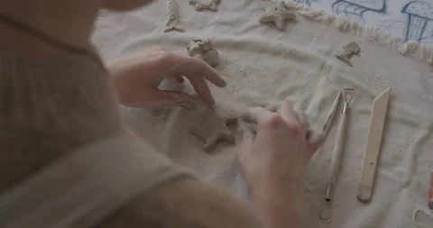 Artist shaping a star from clay using sculpting tools on a linen surface Stock Footage 301617003