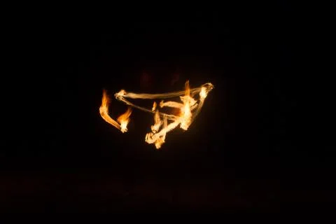 The artist shows a fire show at night spinning torches, circles of fire and l Stock Photos