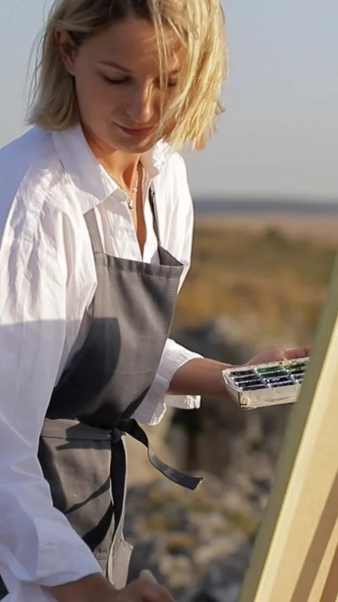 An artist skillfully painting outdoors using vibrant watercolors on a stretched Stock Footage 304962853