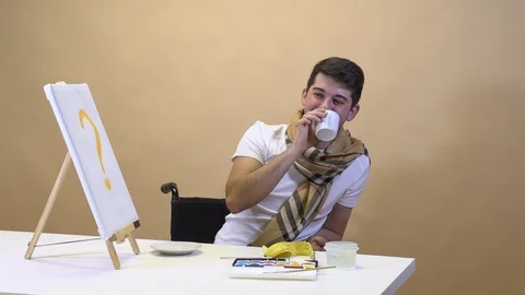 The artist at the table eats a banana and waits for inspiration Stock Footage 125813058