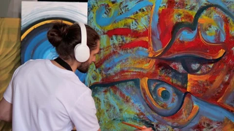 Artist utilizing red, blue, yellow paints to create stunning painting in studio. Video stock 238599162