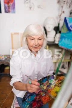 Artist wearing white blouse painting on canvas Stock Photos