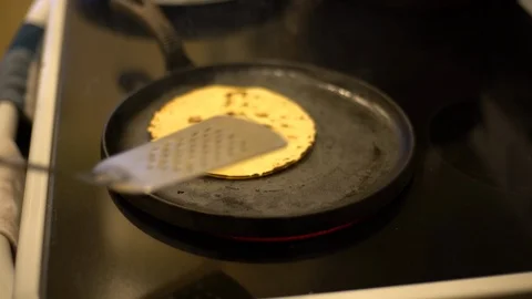Artistic capture of a corn tortilla being flipped on an electric stove Stock Footage 122515530