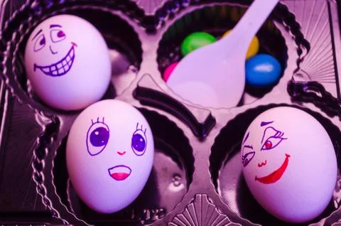 Artistic close-up composition of funny egg family under pink light feeling fo Stock Photos