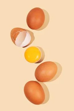 An artistic composition of brown eggs on a pastel yellow background with on.. Stock Photos