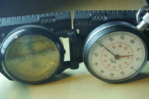 Artistic concept of a compass and a stopwatch with soft light Stock Photos