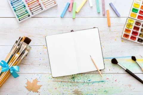 Artistic creative design workspace, notebook mock up for artwork with waterco Stock Photos