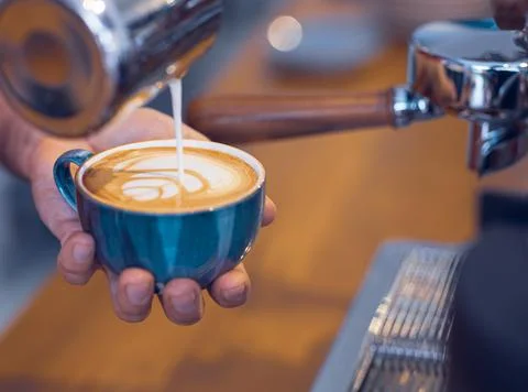 Artistic designed coffee latte view  with coffee beans from a barista desk. Foto stock