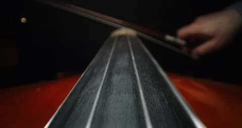 Artistic macro of luthier playing with a bow on a handmade violin or cello. Video stock 115081646