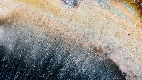 Artistic Macro Shot of Powder Dissolving in Liquid Creating Patterns Stock Footage 317539959