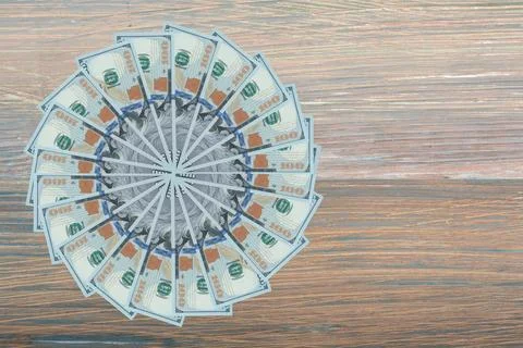 Artistic pattern made from dollar bills Snowflake, flower or star on wooden.. Foto stock