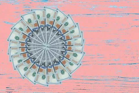 Artistic pattern made from dollar bills Snowflake, flower or star on wooden.. Stock Photos