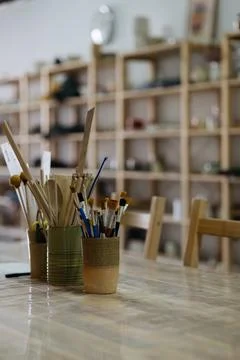 Artistic Pottery Studio Interior with Ceramic Tools and Brushes on a Work Table Stock Photos