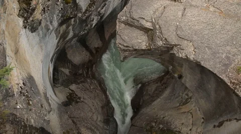 ARTISTIC ROCK FORMATION WITH GREEN WATER RIVER FLOWING THROUGH Stock Footage 59073288