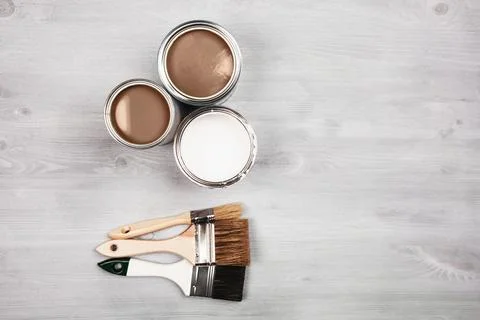 Artistic setup with open paint cans and brushes on a wooden surface Stock Photos