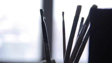 Artist's brushes against the window Stock Footage 70888952