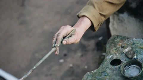 The artist's hand in close-up. He paints a picture sitting on the street Stock Footage 238047464