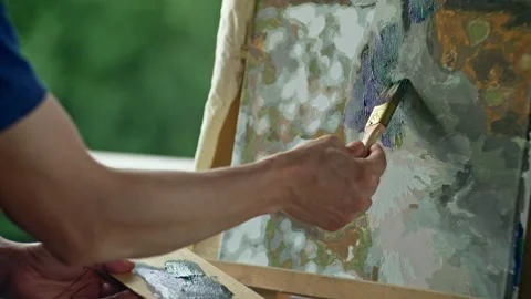 The artist's hands dip the brush in paint and paint a picture. Stock Footage 207752473