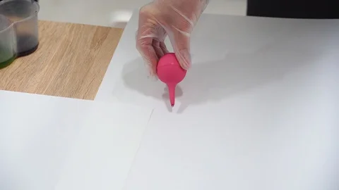 The artist's hands in gloves apply paint to the canvas Stock Footage 129043600