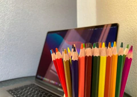 Artist's set. Colored pencils for drawing standing in a green mug. Stock Photos