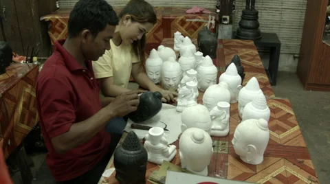 Artists working with ceramic Buddha heads in a Cambodian workshop Stock Footage 48026754