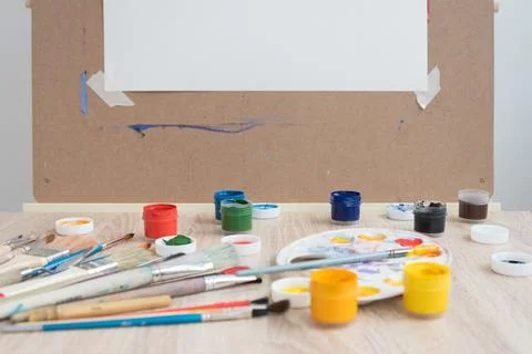 Artist's workplace. Everything is ready for work. Brushes, paints, palette Stock Photos