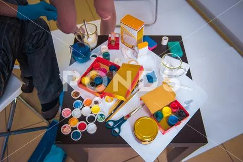 Artist's workshop. Canvas, paint, brushes, palette knife lying on the table. Stock Photos