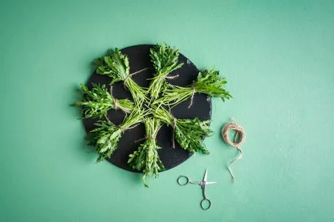 Arugula bundles on platter on green table. Making arugula bundle Stock Photos