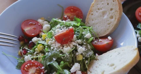 Arugula salad with soft cheese, cherry tomatoes, sweetcorn and pomegranate seed Stock Footage 121318158