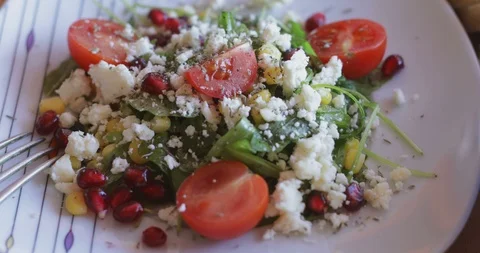 Arugula salad with soft cheese, cherry tomatoes, sweetcorn and pomegranate seed Stock Footage 121326244