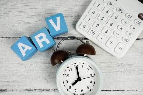 ARV (Average Retail Value) text with alarm clcok and calculator on wooden b.. Stock Photos
