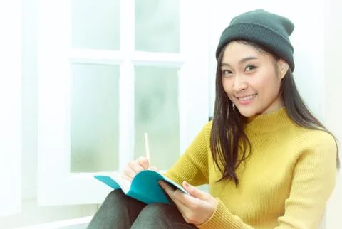 Asain woman write notes near the window, relaxing lifestyle Stock Photos