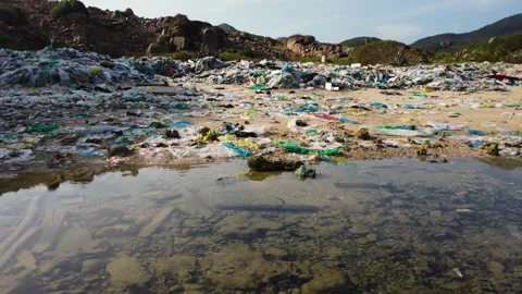 Ascend drone shot showing plastic bottle,waste and garbage on sandy beach Vidéo 170938129