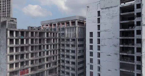 Ascending aerial unfinished buildings, developing cityscape, and distant hills. Stock Footage 329903834