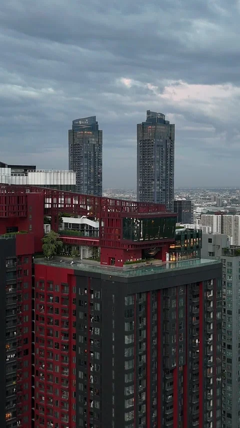 Ascending Aerial View of Modern Red Skyscraper Rooftop Pool in Bangkok, Thailand Stock Footage 335585624
