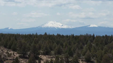 Ascending aerial view of snow capped Mount Bachelor from Bend Oregon in spring Stock Footage 335728122