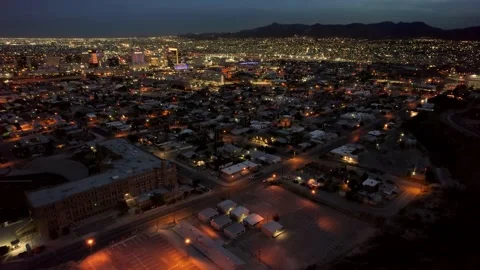 Ascending and looking down over downtown El Paso at night with Juarez in Stock Footage 202003383