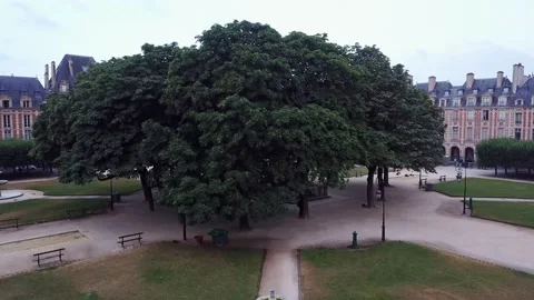 Ascending camera in park revealing uniform houses lining square and wide Stock Footage 176448321