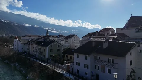 Ascending Drone Flight from Alpine Stream Revealing Townscape in South T Stock Footage 335686348