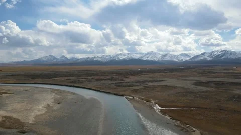 Ascending Drone Over Plateau River and Snow Mountains Qilian Qinghai China Video stock 330457536