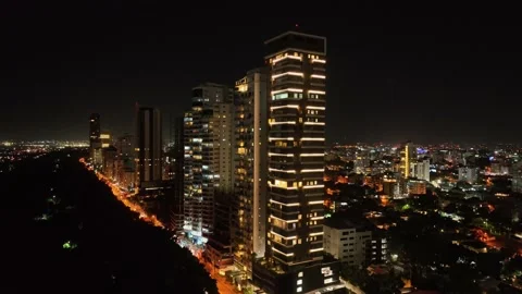 Ascending drone shot of Lighting city of Santo Domingo at night with Stock Footage 232454773