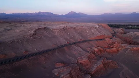 Ascending drone shot rising over a desert road cutting through red rock Stock Footage 333176095